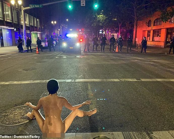 A protester dubbed 'Naked Athena' confronted Portland police wearing only a face mask and beanie