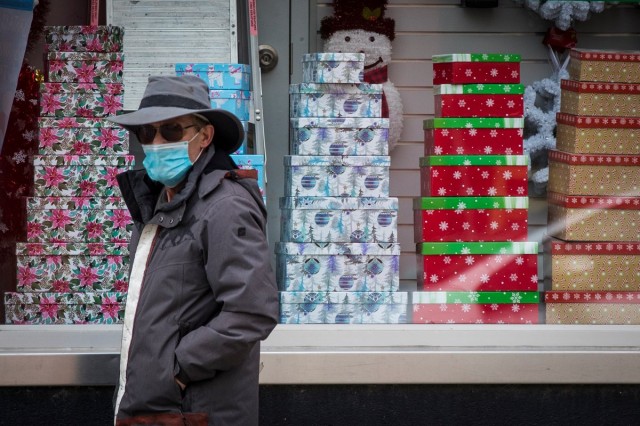 A person wears a mask as they walk past Christmas decorations in a store in Kingston, Ontario on Thursday, November 19, 2020, as the COVID-19 pandemic continues across Canada and around the world.