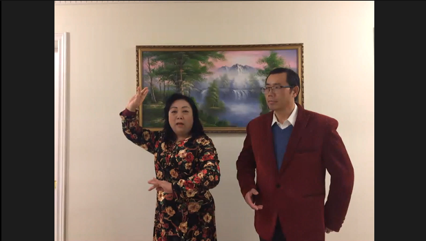 Two people standing in front of a painting Description automatically generated with medium confidence