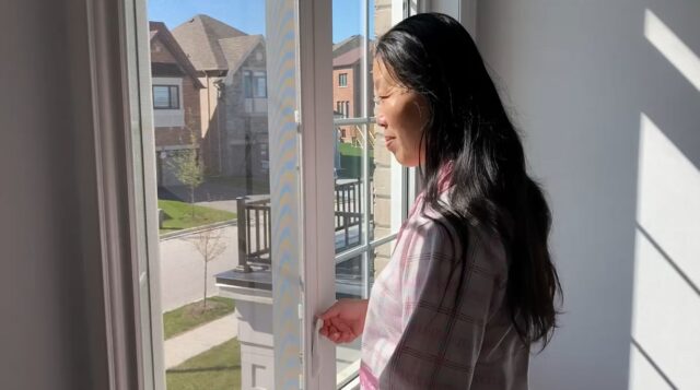 A person looking out a window Description automatically generated with medium confidence