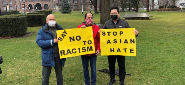 A group of men holding signs Description automatically generated with medium confidence