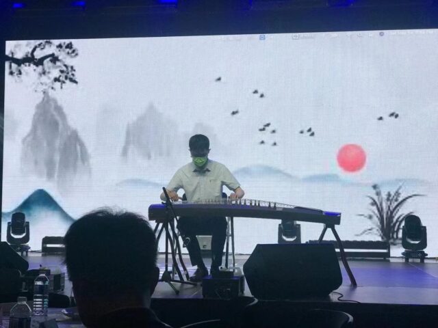 A person playing a keyboard on a stage Description automatically generated with medium confidence