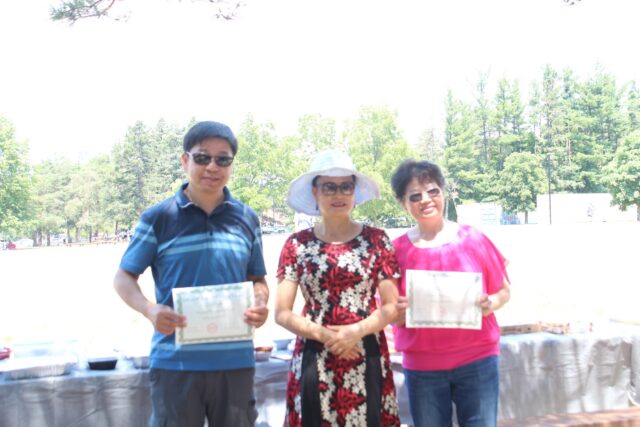 A group of people holding papers Description automatically generated with low confidence