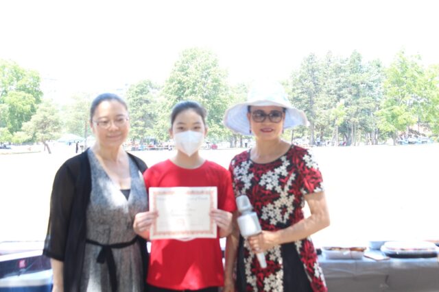 A group of women holding a plaque Description automatically generated with low confidence