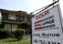 A realtor's sign stands outside a house for sale in Toronto