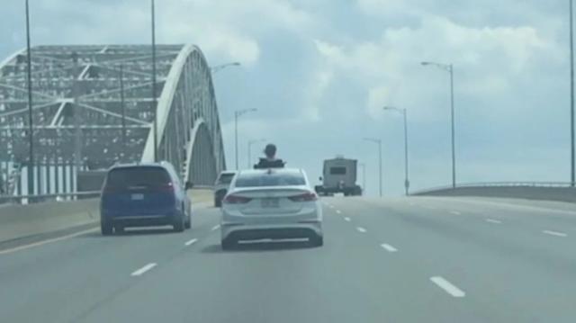 ​Someone hanging outside sunroof on the QEW.