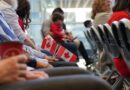 Seated people hold tiny Canadian flags.