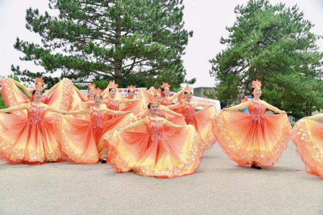 A group of women in orange dresses Description automatically generated with medium confidence