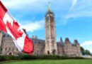 Canadian flag with the Canadian Parliament building in the background.