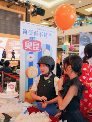 A young child wearing a helmet and standing next to a sign Description automatically generated