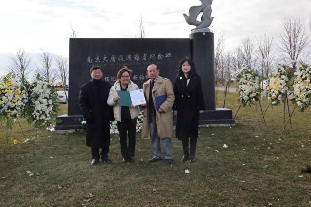 A group of people standing in front of a grave Description automatically generated