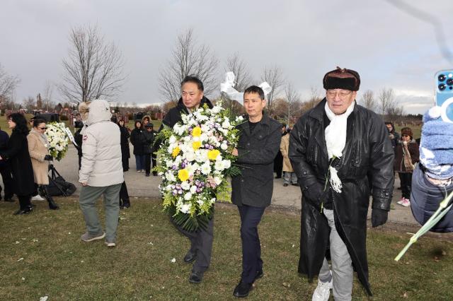 A group of people walking with flowers Description automatically generated