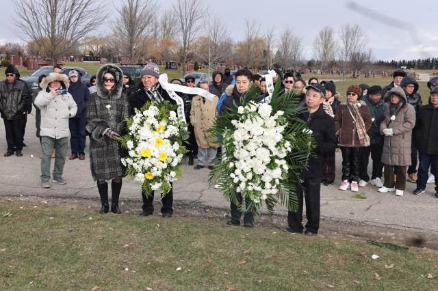 A group of people holding flowers Description automatically generated