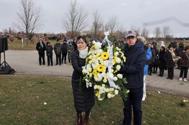 A person and person holding a large bouquet of flowers Description automatically generated