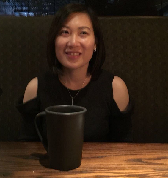 A person sitting at a table with a mug Description automatically generated