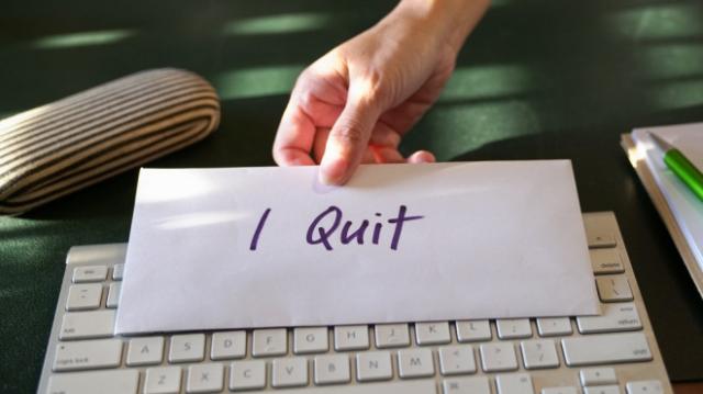 This stock image shows a hand holding a letter of resignation. (Credit: Shutterstock)