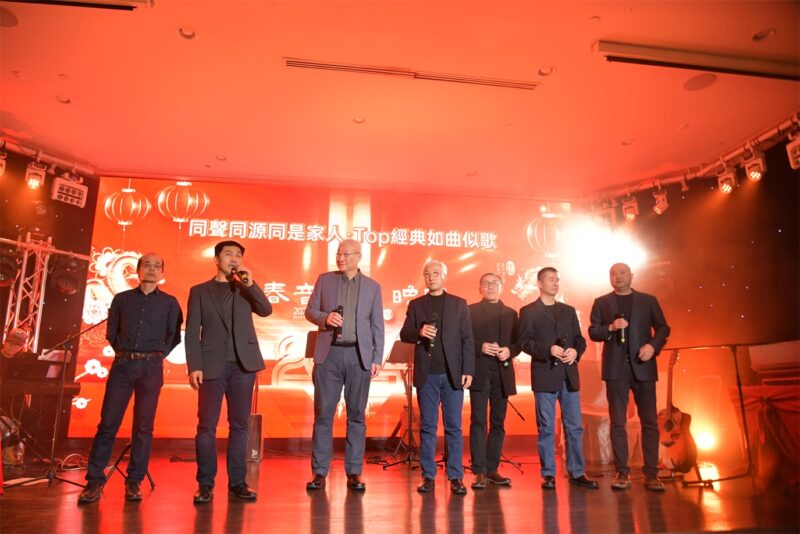A group of men singing on stage

Description automatically generated