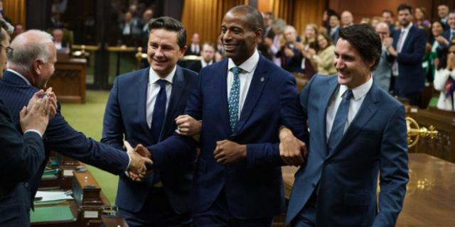 Leader of the Opposition Pierre Poilievre and Prime Minister Justin Trudeau drag new House Speaker Greg Fergus to the Speaker's chair in the House of Commons on October 3.
