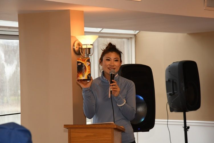 A person holding a microphone and holding a box Description automatically generated
