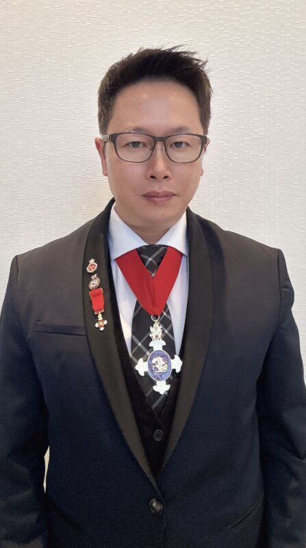 A person in a suit with medals Description automatically generated