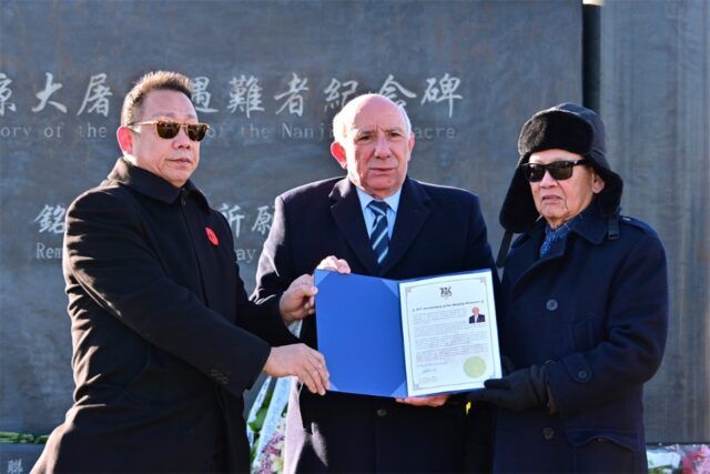 A group of men holding a document Description automatically generated