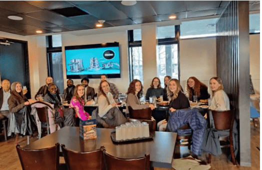A group of women sitting around a table AI-generated content may be incorrect.