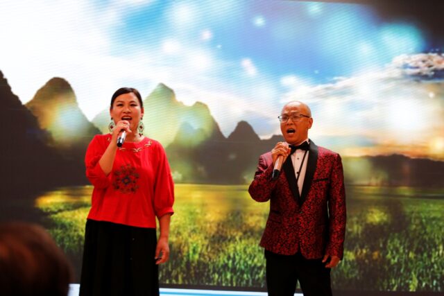 A person and person singing into microphones

AI-generated content may be incorrect.